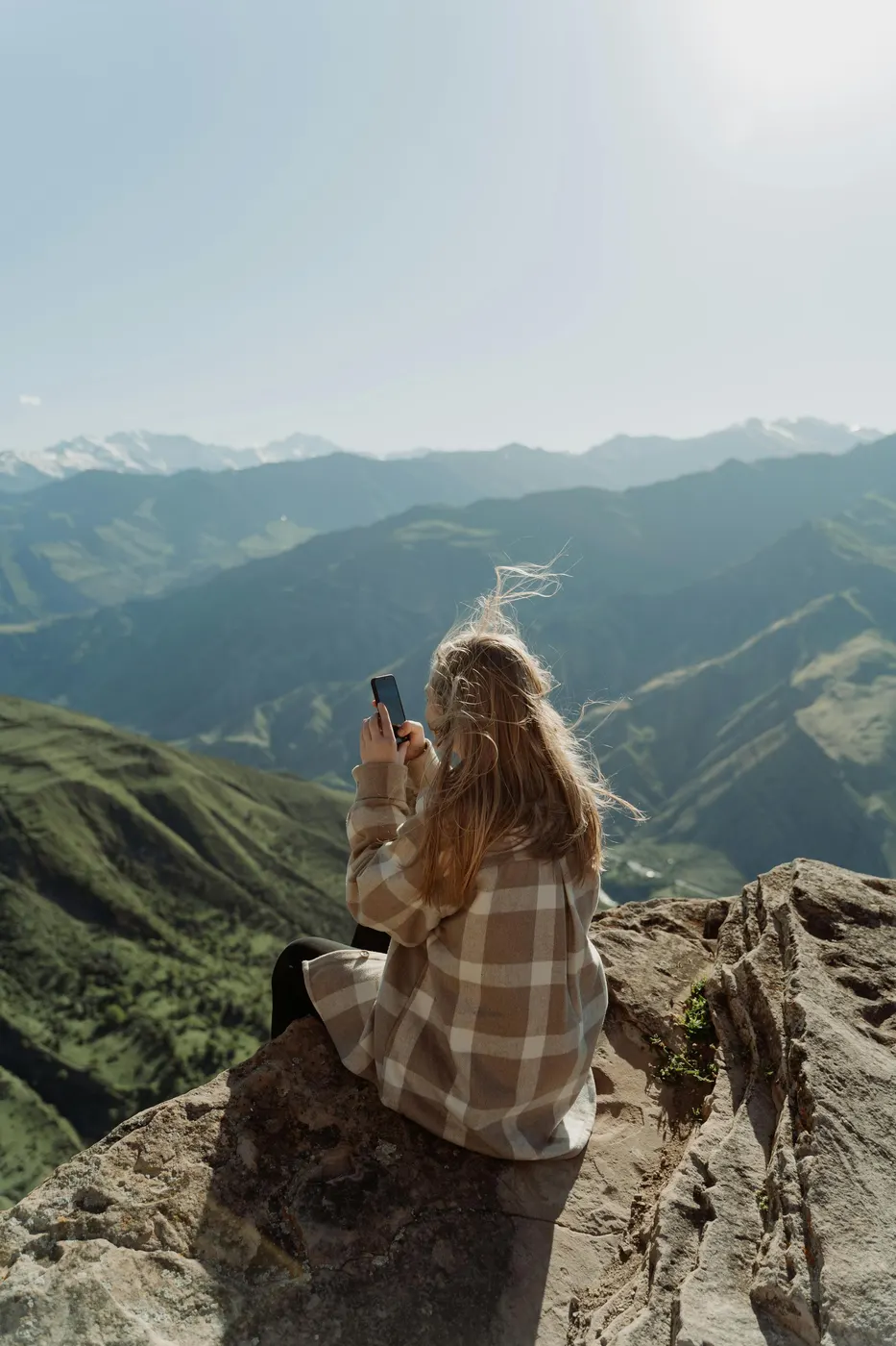 Pessoa no alto de uma montanha fotografando a paisagem com o celular
