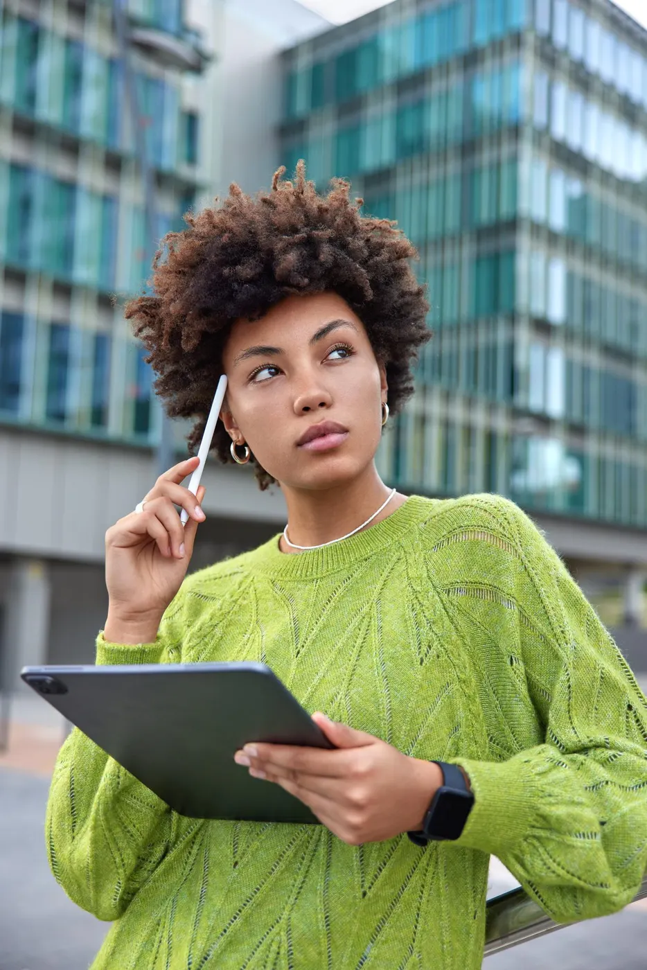 Profissional com tablet em frente a prédios corporativos